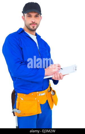 Handyman in blue overall writing on clipboard Stock Photo