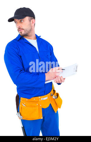 Handyman in blue overall writing on clipboard Stock Photo