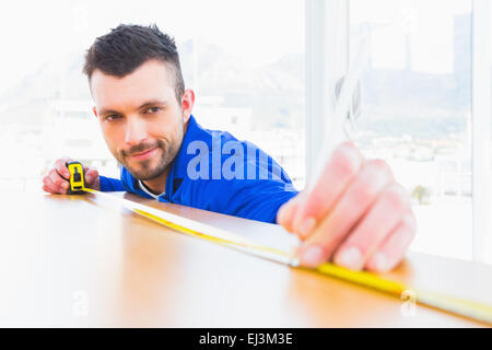 Handyman measuring wood board Stock Photo