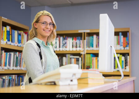 Pretty librarian working in the library Stock Photo