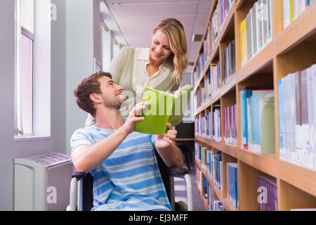 Smiling disabled student with classmate in library Stock Photo