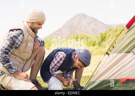 Father and son pitching their tent Stock Photo