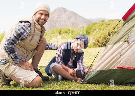 Father and son pitching their tent Stock Photo