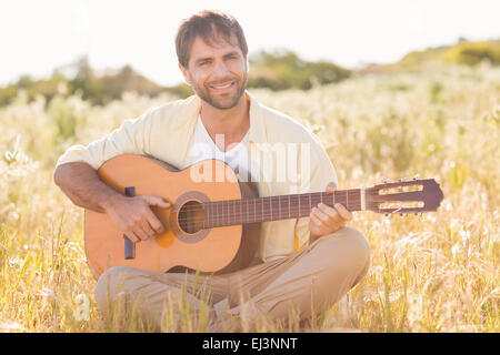 Happy man smiling and playing guitar Stock Photo