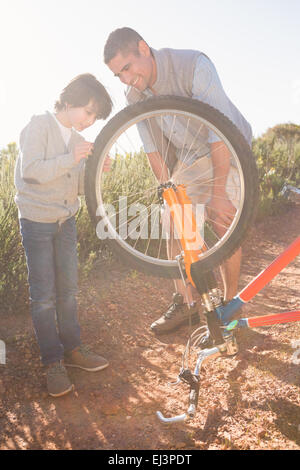 Father and son repairing bike together Stock Photo