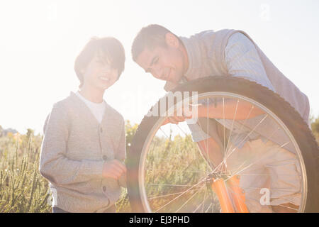 Father and son repairing bike together Stock Photo