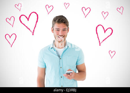 Composite image of handsome young man using his smartphone Stock Photo