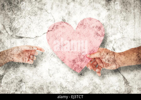 Composite image of couple passing a paper heart Stock Photo