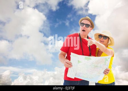Composite image of happy tourist couple using map Stock Photo