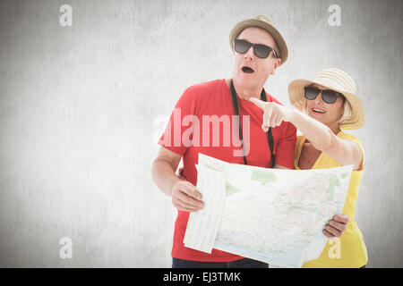 Composite image of happy tourist couple using map Stock Photo