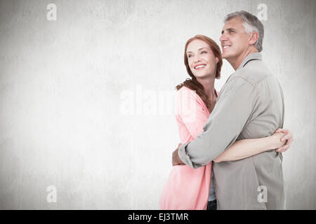 Composite image of casual couple hugging and smiling Stock Photo