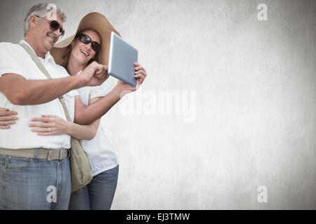 Composite image of vacationing couple taking photo Stock Photo
