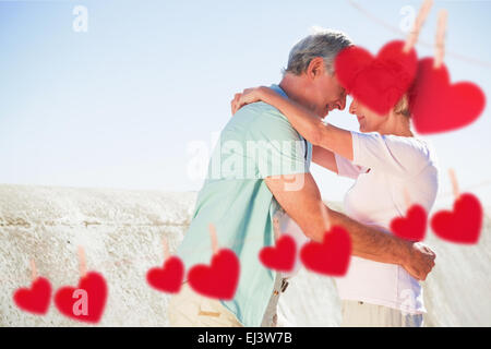 Composite image of happy senior couple embracing on the pier Stock Photo