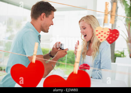 Composite image of man proposing marriage to his shocked blonde girlfriend Stock Photo