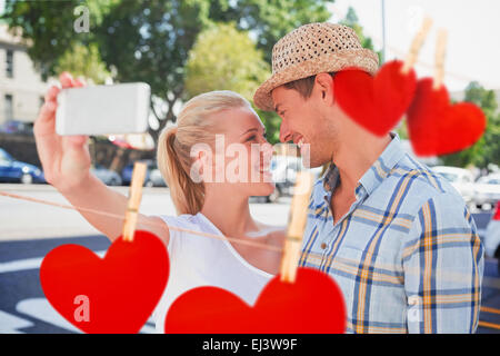 Composite image of young hip couple taking a selfie Stock Photo