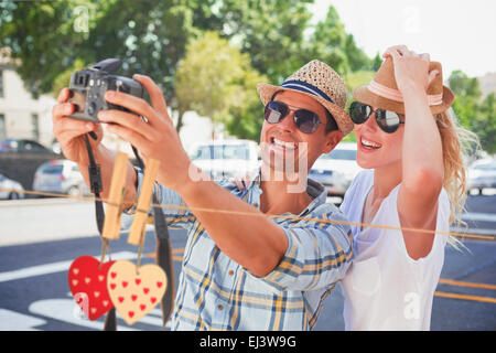 Composite image of young hip couple taking a selfie Stock Photo