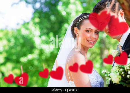 Composite image of loving bride and groom in garden Stock Photo