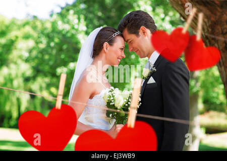 Composite image of loving newly wed couple in garden Stock Photo