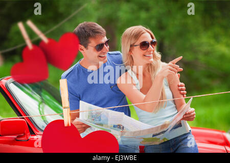 Composite image of cheerful young couple reading map Stock Photo