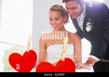 Composite image of happy young couple signing wedding register Stock Photo