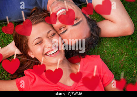 Composite image of two friends smiling while lying head to shoulder with an arm behind their head Stock Photo