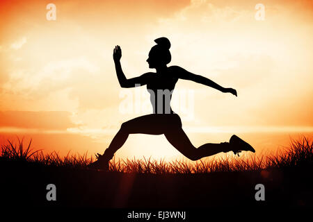 Composite image of fit brunette running and jumping Stock Photo