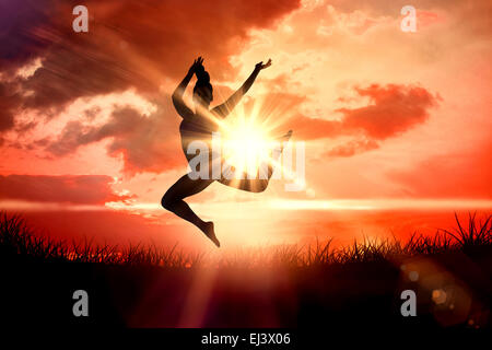 Composite image of fit brunette jumping and posing Stock Photo