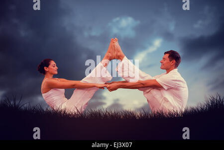 Composite image of peaceful couple sitting in boat position together Stock Photo