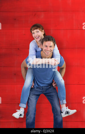 Composite image of man giving girl a piggy back Stock Photo