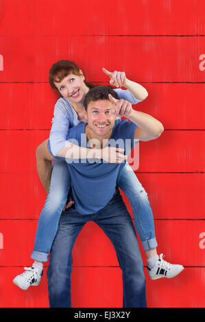 Composite image of man giving girl a piggy back Stock Photo
