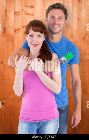 Composite image of couple hugging and holding brush Stock Photo