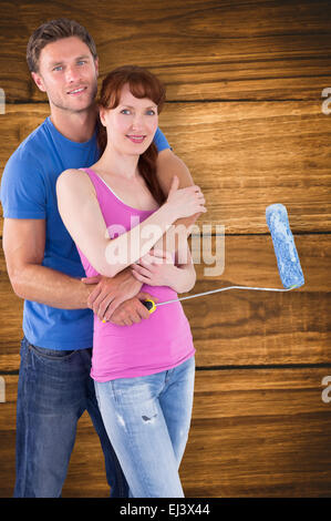 Composite image of couple hugging and holding brush Stock Photo