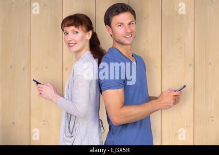 Composite image of couple both sending text messages Stock Photo