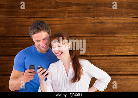Composite image of couple using their mobile phones Stock Photo