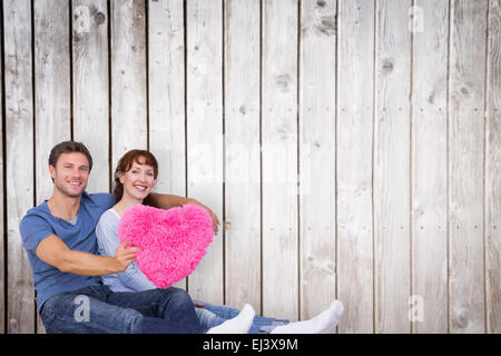Composite image of couple holding a large heart Stock Photo