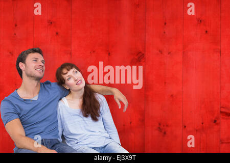 Composite image of couple sitting on floor together Stock Photo