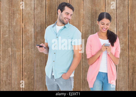 Composite image of happy couple sending text messages Stock Photo