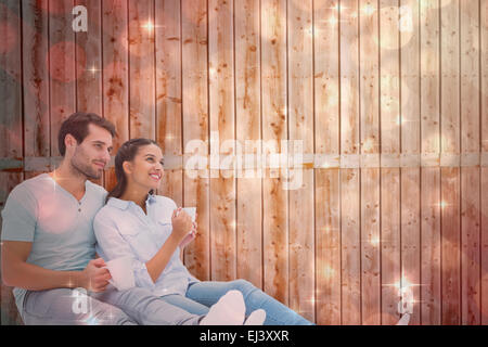 Composite image of cute couple sitting having coffee Stock Photo