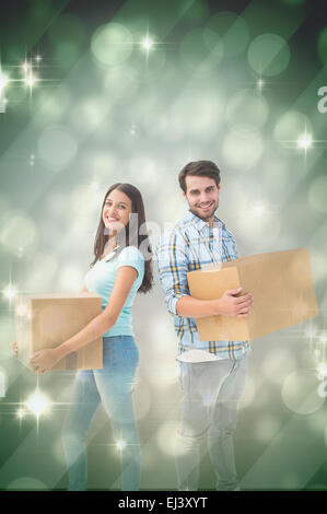 Composite image of happy young couple with moving boxes Stock Photo