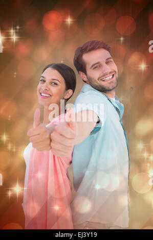 Composite image of happy couple showing thumbs up Stock Photo