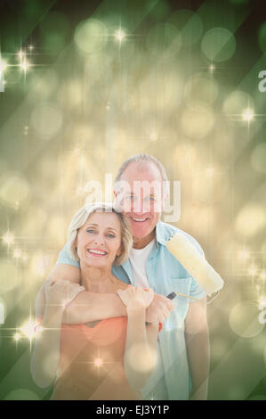 Composite image of happy older couple holding paint roller Stock Photo