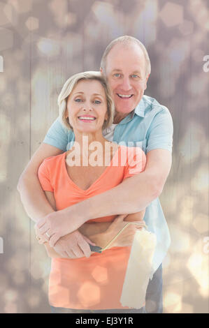 Composite image of happy older couple holding paint roller Stock Photo