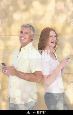Composite image of casual couple sending text messages Stock Photo