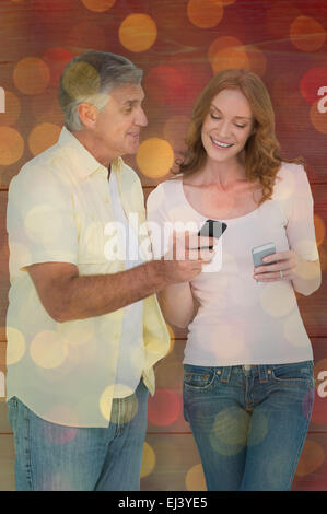 Composite image of casual couple sending text messages Stock Photo