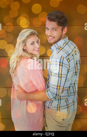 Composite image of attractive couple turning and smiling at camera Stock Photo