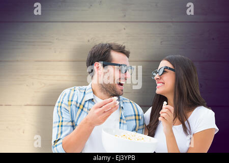 Composite image of attractive young couple watching a 3d movie Stock Photo