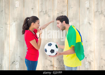 Composite image of brunette sending off a brazilian fan Stock Photo