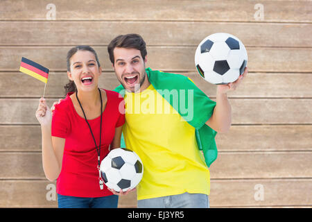 Composite image of football fan couple cheering and smiling at camera Stock Photo