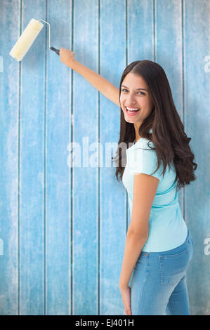 Happy pretty young woman painting a wall Stock Photo - Alamy