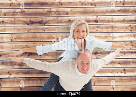 Composite image of happy mature couple having fun Stock Photo